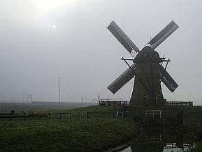 De molen malend in de mist.